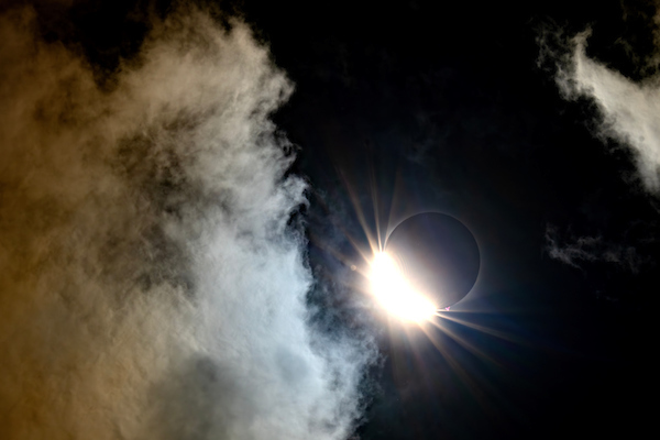 eclipse surrounded by clouds